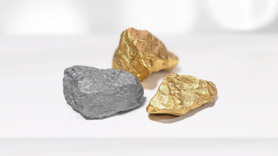 Bilde av to gullklumper og en grå stein.