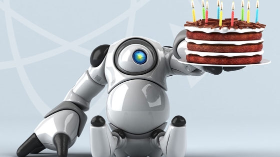 Robot som holder en bursdagskake.